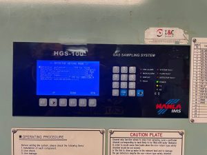Technician servicing an IMS Hanla HGS-100 fixed gas sampling system onboard a vessel checking flow, calibrating sensors, and configuring alarms for ISM/IMO compliance.