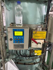 Oil Content Monitor and 15 ppm bilge alarm panel installed onboard a vessel, showing operational status during inspection and calibration service in Spanish ports including Algeciras, Gibraltar, Huelva, Cartagena, Barcelona, and Bilbao.