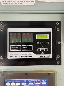 Daihatsu MD SX oil mist detector controller showing multi channel bar indicators green status lights and control keypad mounted on an engine room panel.