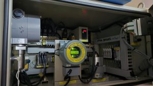 RKI Riken Keiki fixed gas sampling system installed inside a control cabinet, showing an explosion proof gas detector during calibration and health check service in Spain including Algeciras, Gibraltar, Huelva, Cartagena, Barcelona, and Bilbao.