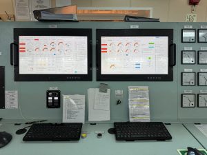 Marine alarm control system with dual operator screens showing engine and alarm status during calibration and system health check on board a vessel.