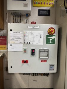 Gas sampling system control panel with sensors, flow indicators and alarms undergoing inspection and troubleshooting during marine service